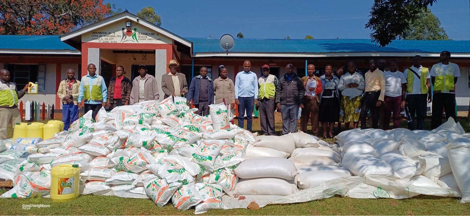 Bags of relief food laid out for distribution, with Good Neighbors staff and community members