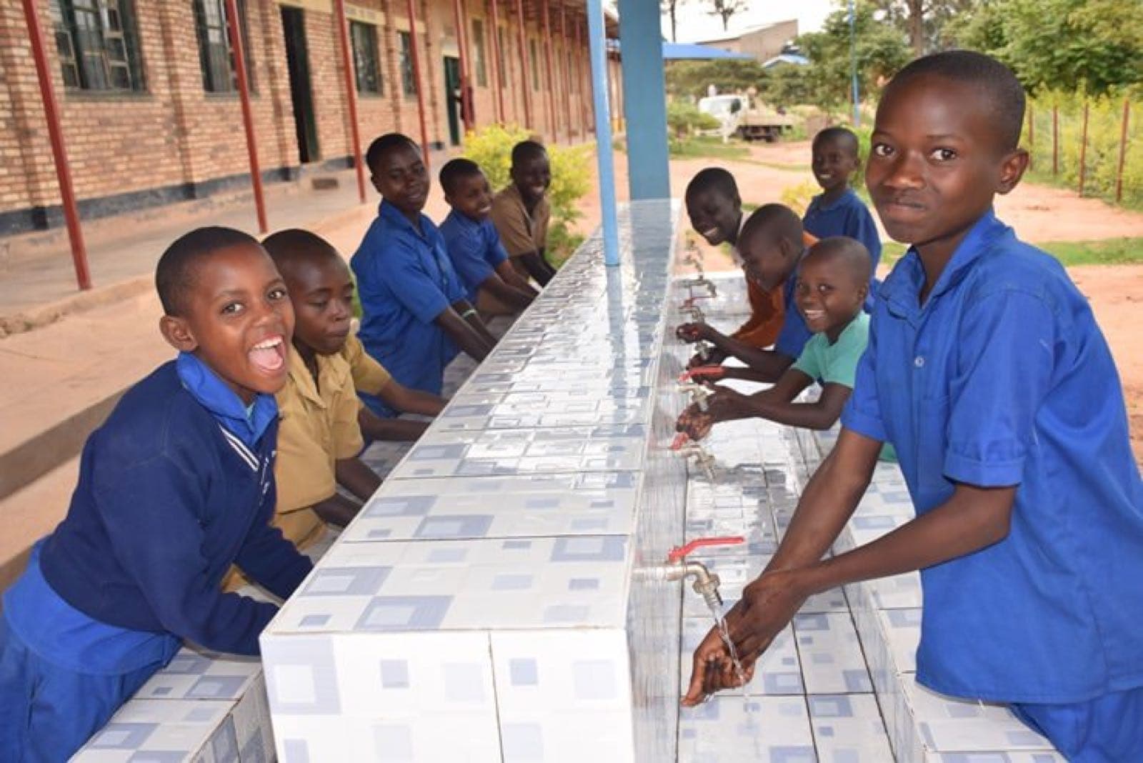 Pupils washing their hands at a school handwashing station